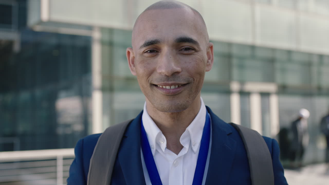 retrato en primer plano de un hombre de negocios calvo hispano que mira sonriendo a la cámara de la oficina corporativa