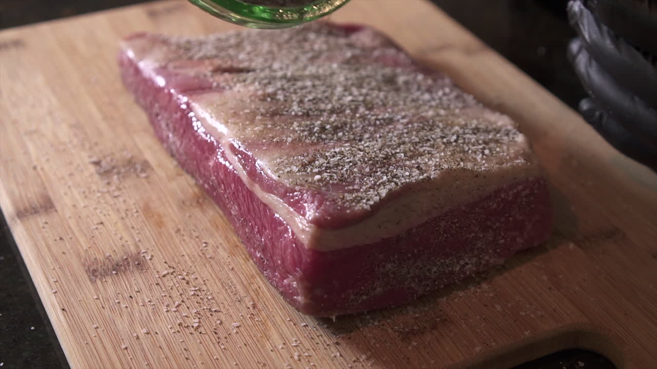 chef con guantes negros de calidad alimentaria preparando pechuga de res para ahumar