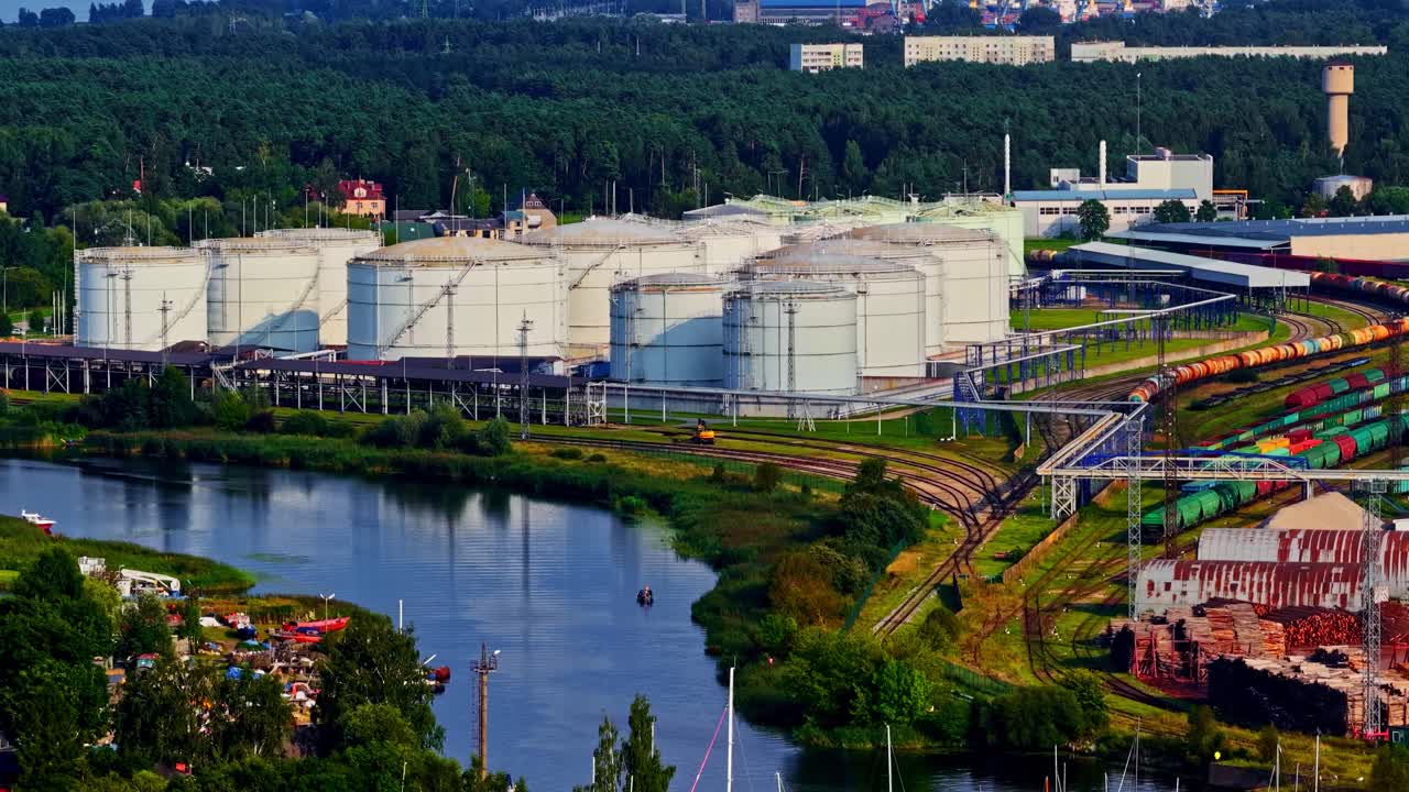 Liquefied natural gas storage tanks at the Riga, Latvia sea port terminal where the Daugava River flows into in the Baltic Sea - pullback aerial view