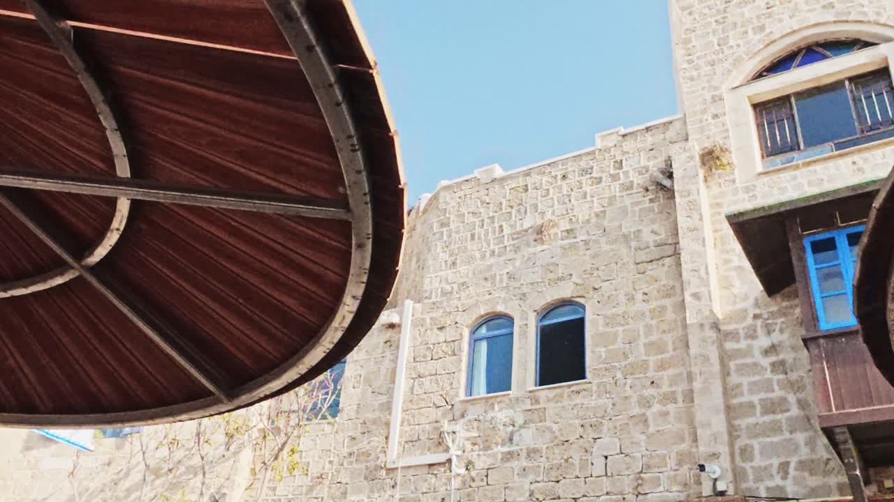 Storica facciata in pietra con porta blu e segnaletica in ebraico