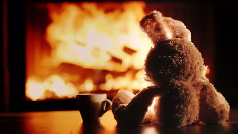 lonely plush rabbit admires the fire in the fireplace insert slow motion video