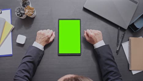 hombre de negocios desplazándose y deslizando la aplicación de negocios en la tableta con pantalla verde