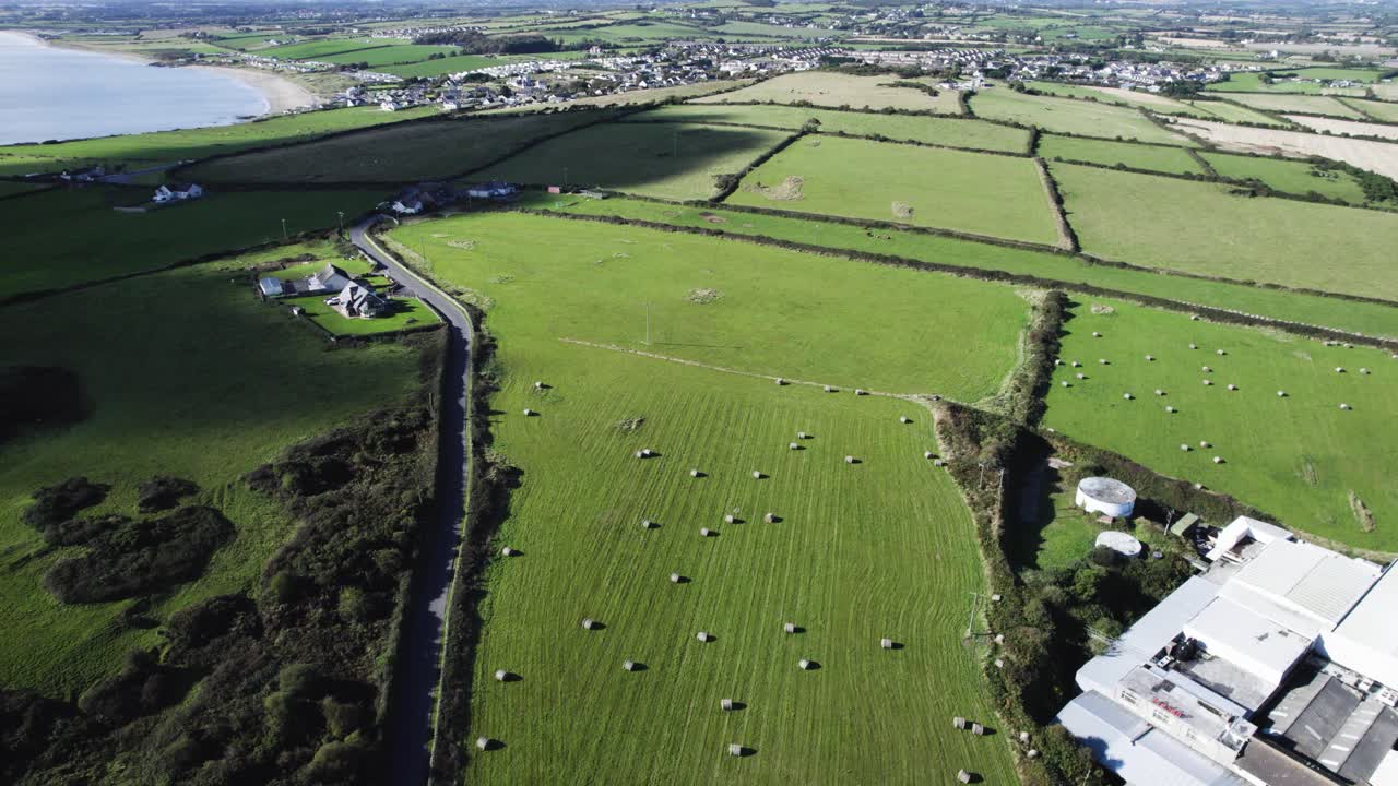 Drone flight over Irish coastline fields, while cloud shadows cut across the grass