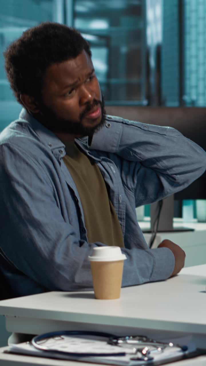 African American Man Experiencing Neck Pain While Working in Office