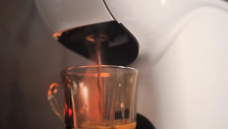 proceso de hacer café con cafetera nespresso en una taza de vidrio