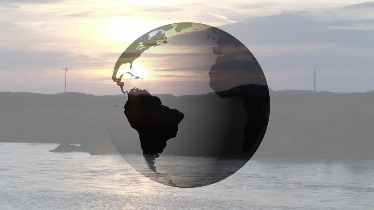 Transparent globe hovering over coastal sunset scene, reflecting warm golden hues on calm water