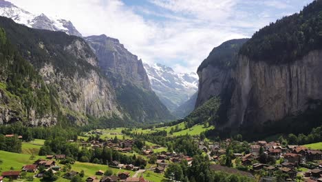 aerial view : lauterbrunnen valley in switzerland on a sunny day, famous tourist destination, swiss staubbach waterfall alpine village with pine trees mountains and picturesque green meadows