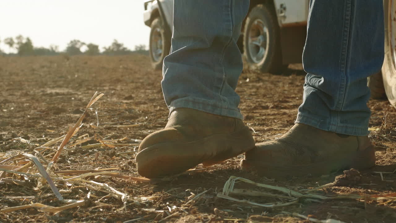 Farmer's boot kicking up dust in field during Australian Drought