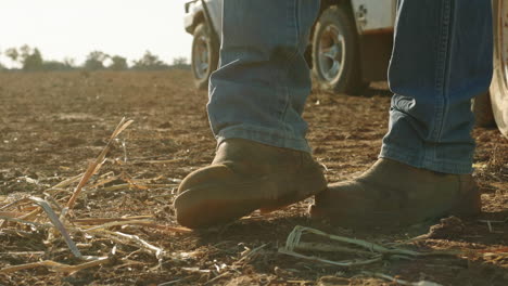 la bota del granjero pateando el polvo en el campo durante la sequía australiana