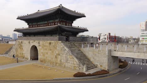 coreanos con máscaras protectoras durante covid-19 visitando la puerta norte de janganmun de la fortaleza de hwaseong