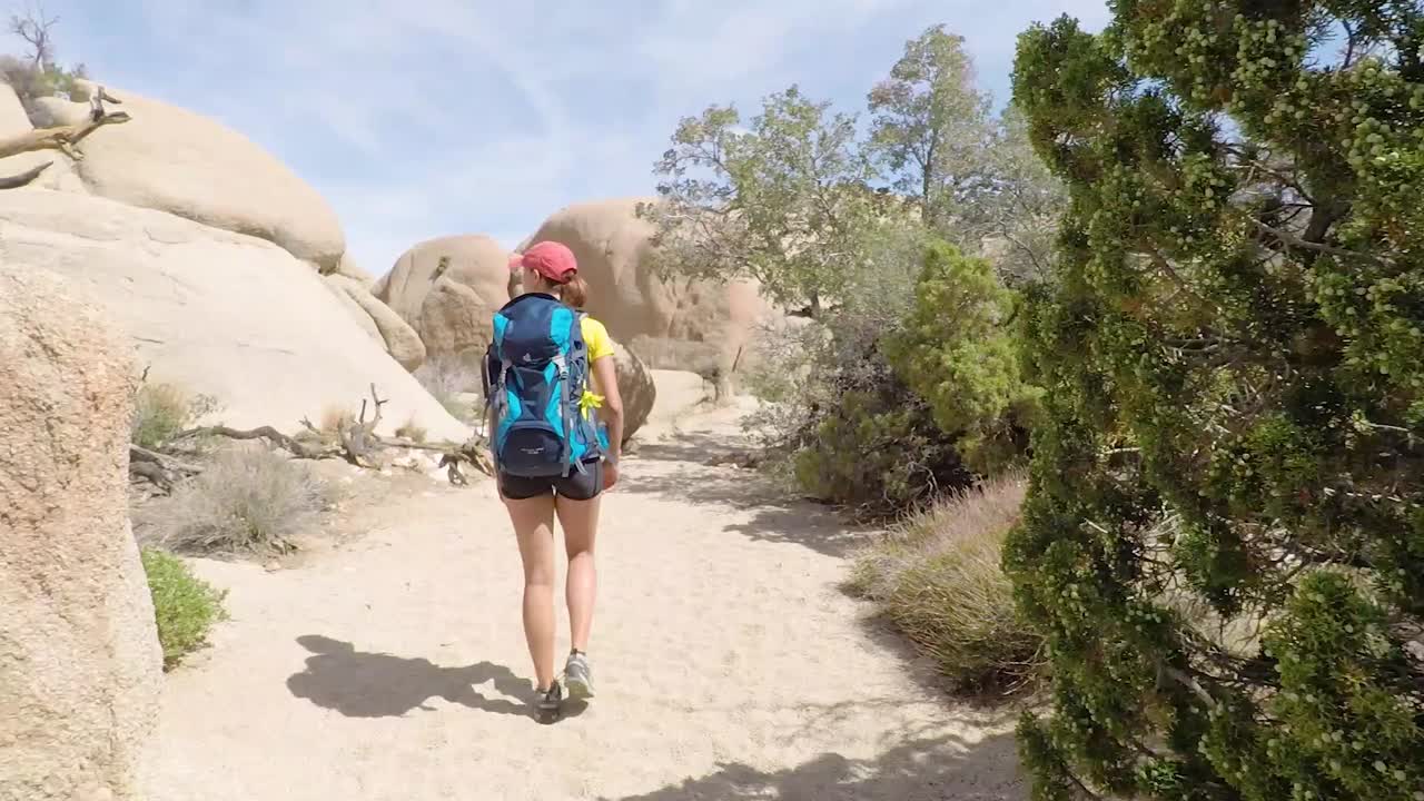 mujer joven caminando en el parque nacional joshua tree, california, ee.uu.