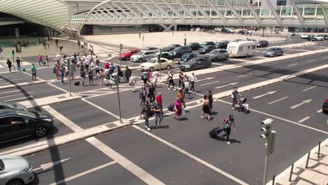 people crossing the road in front of the gare do oriente (orient station) in parque das nacoes. public transport hub designed by the architect santiago calatrava