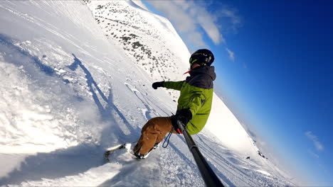 taking selfie of the ride on the snowboard. sportsman goes down the mountain slope recording his descend.