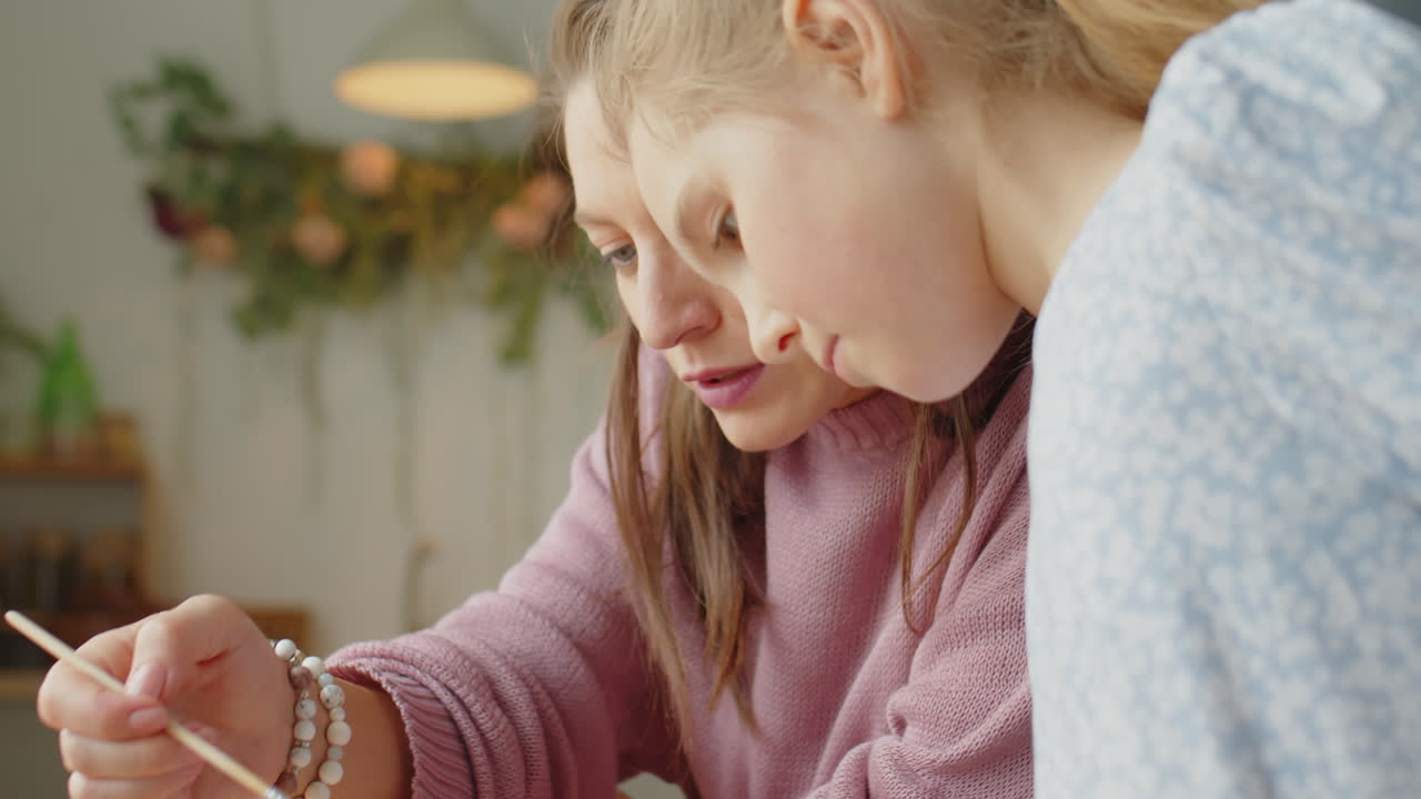 Girl Painting Easter Egg with Mother