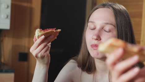 young girl in towel enjoying a slice of pizza with a blissful expression, savoring the delicious food in a cozy indoor setting, captured in a relaxed atmosphere, she is having a good time
