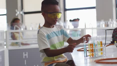 Video-of-happy-african-american-boy-wearing-glasses-during-chemistry-lesson