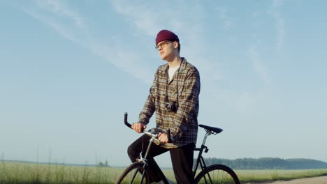 man riding a bicycle in a rural landscape