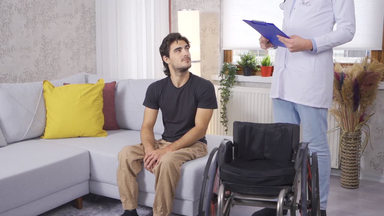 Disabled young man being examined by doctor at home. Slow Motion.
