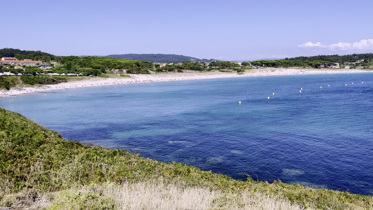 Filmato panoramico di una spiaggia idilliaca circondata da foresta e acqua azzurra in Spagna