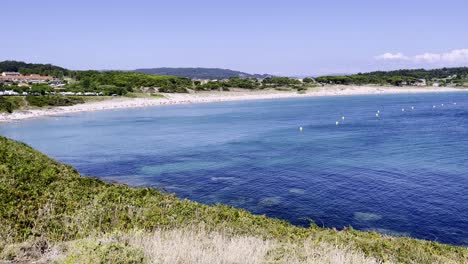 Schwenkaufnahmen-Eines-Idyllischen-Strandes,-Umgeben-Von-Wald-Und-Blauem-Wasser-In-Spanien