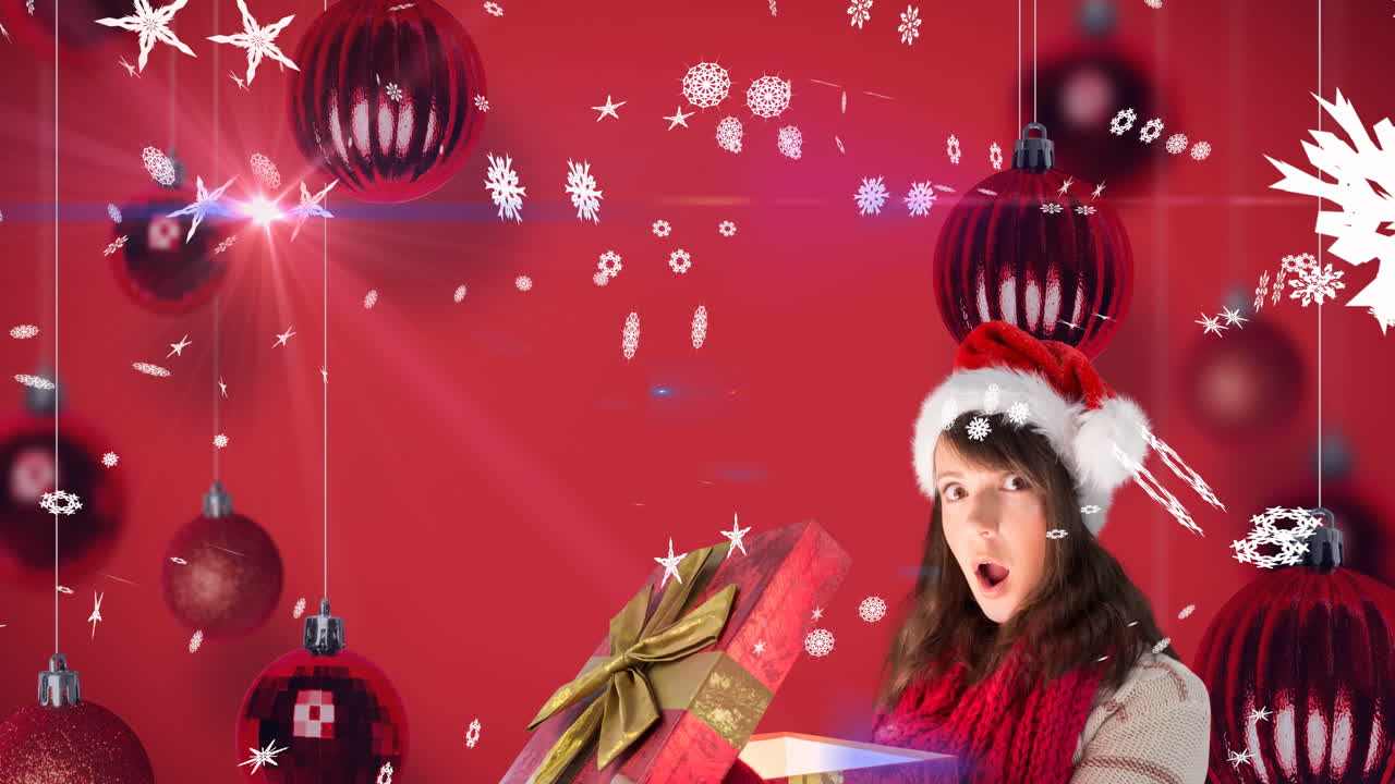 animación de nieve cayendo sobre feliz mujer caucásica con sombrero de santa manteniendo presente