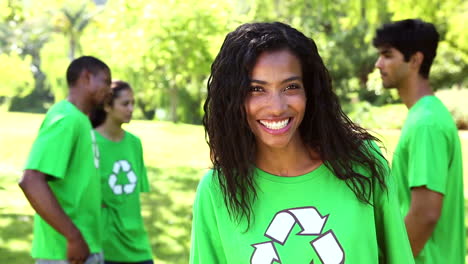 activista ambiental feliz sonriendo a la cámara con el equipo detrás de ella