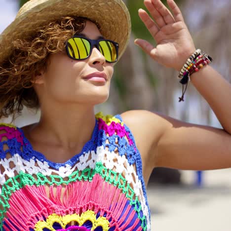 Grinning-woman-in-sunglasses-and-hat-near-ocean