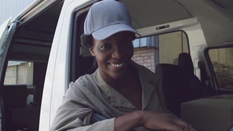 portrait of young female van driver with a warehouse delivery