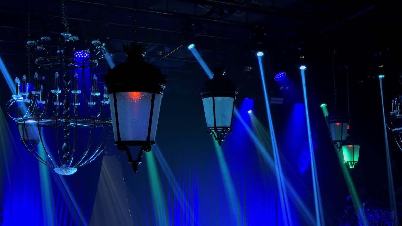 Dynamic 4K footage of colorful stage lights and laser beams moving through a dark nightclub interior, capturing a high-energy entertainment and party atmosphere