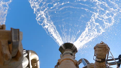 looking up view of spraying water truck compressing soil on construction site, 4k