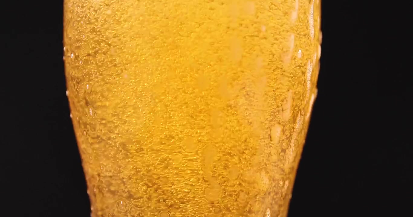 Versare birra artigianale fresca con piccole bollicine e schiuma in un bicchiere