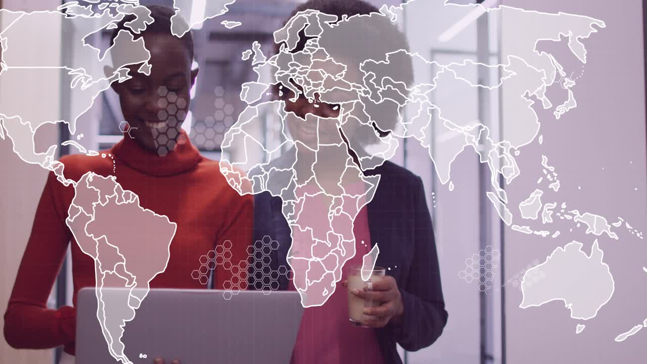 Two co-workers tapping laptop trackpad in business office with coffee and growing hex-map overlay