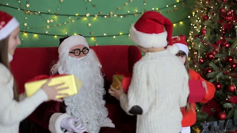 American Santa Claus Gives Gifts to Obedient Children Christmas Holiday Santa Claus with a Group of Children in the United States Holding Gifts in their Hands Happy Children
