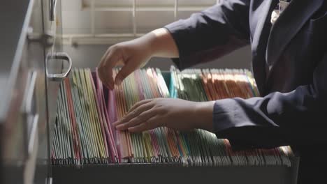 female staff searching for documents in the office filing cabinet