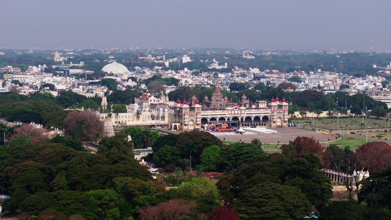 Bredt udsyn over Mysuru Paladset med guldbelagt kuppel, Shri Shvethavaraha Swami Gudi og Dr B R Ambedkar Bhavana i Mysore, Karnataka, Indien. Dagtid, semi-orbit skud, droneoptagelse, 4K.
