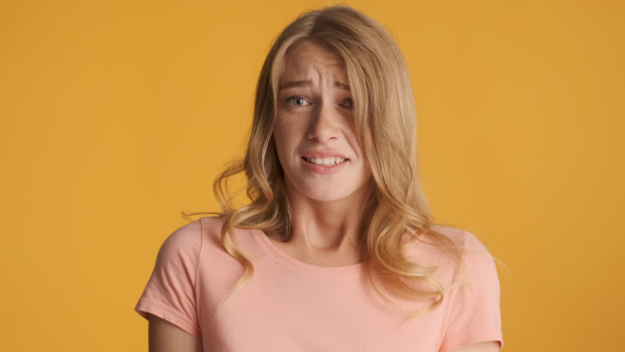 una mujer caucásica que se ve asustada ante la cámara.