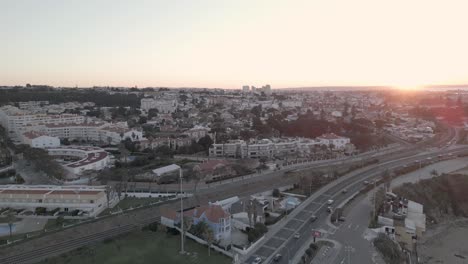 Luftaufnahme-Des-Atemberaubenden-Sonnenaufgangs-über-Der-Skyline-Von-Lissabon,-Der-Die-Schönheit-Und-Den-Charme-Der-Stadt-In-Portugal-Zeigt