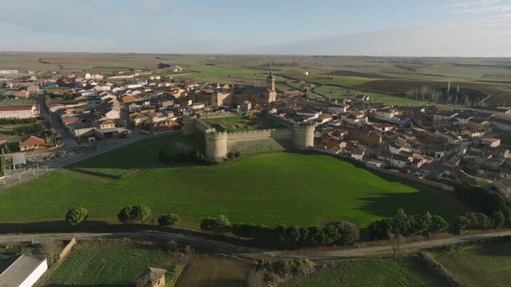 Veduta aerea: castello fortezza, prati verdi del villaggio di Grajal de Campos in Spagna, panorama diurno.