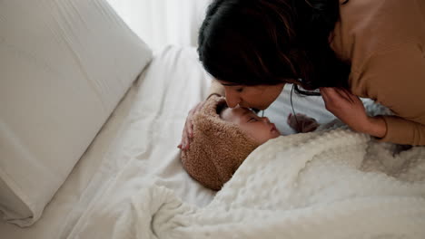 a mother tucking in her baby daughter for bedtime