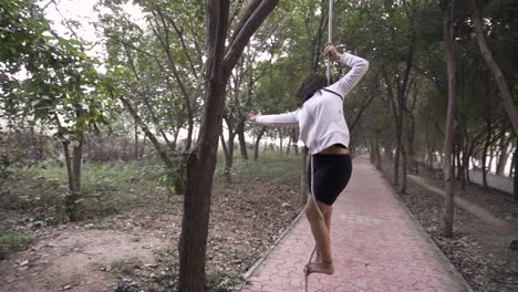 a sporty gymnast performs exercises with a rope in sportswear