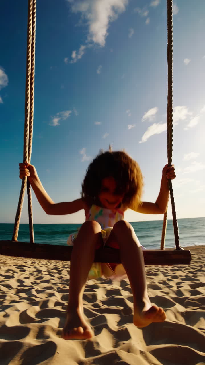 Bambino gioioso che dondola sulla spiaggia al tramonto.
