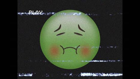 digital animation of vhs glitch effect over green sick face emoji against black background