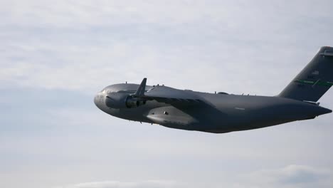 c-17 military cargo plane flying with bright sky background