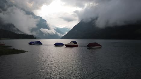 moody mountain lake with boats