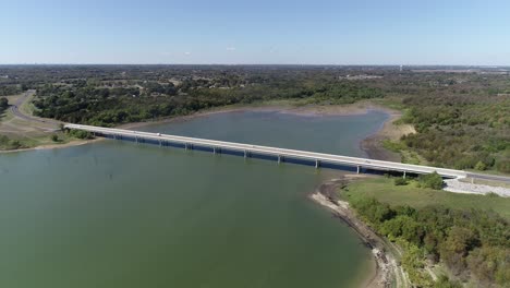 Luftbildvideo-Des-Lake-Lavon-Auf-Der-Nordwestseite-Mit-Einem-Auto,-Das-über-Die-Brücke-Fährt