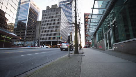 cars driving on a busy downtown street in an urban city