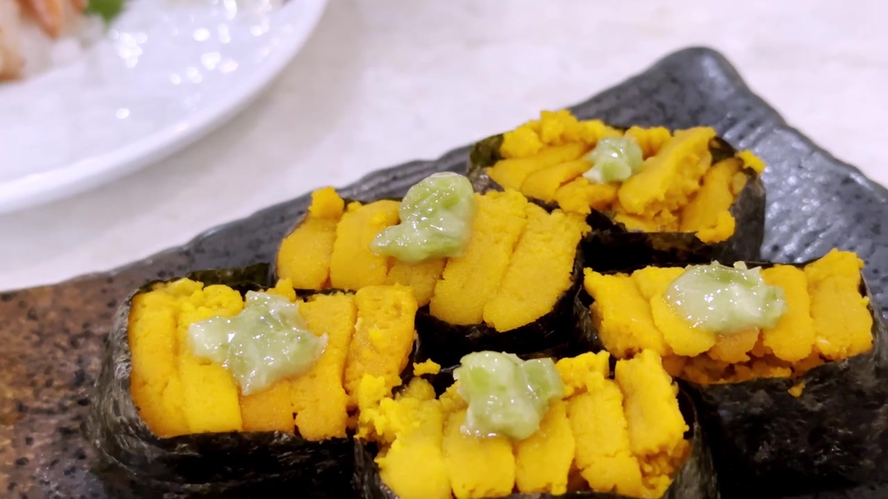 Primo piano di sushi uni fresco con riccio di mare di alta qualità servito su riso giapponese condito, che evidenzia una consistenza ricca e una presentazione gourmet autentica