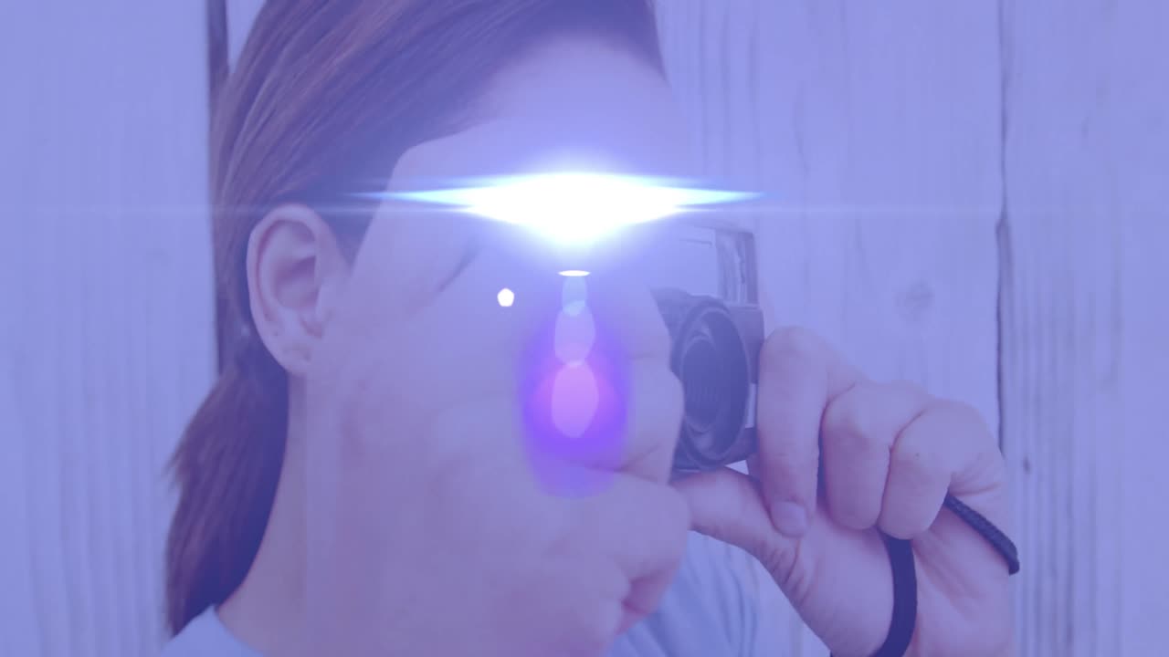 punto de luz contra una fotógrafa afroamericana haciendo clic en imágenes con una cámara digital