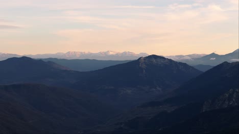 panorámica aérea sobre las montañas del profundo valle de agrafa, grecia, en la hora azul con un suave resplandor dorado en el horizonte