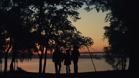 Eltern-Kind-Silhouette-Hält-Sich-An-Den-Händen-Und-Geht-Gemeinsam-Zum-Sonnenuntergang-über-Dem-Fluss-Und-Dem-Meer.